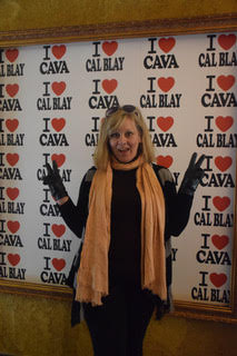 Becky Lukovic in front of a sign saying "I heart Cava, Cal Blay"